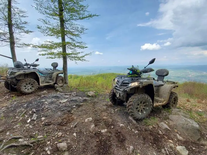 Două ATV-uri pe stâncă, deasupra văii
